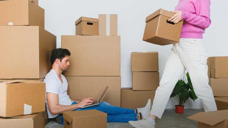 Young couple settling in new apartment surrounded by packing boxes, managing tasks on a laptop., tags: washington, - pexel