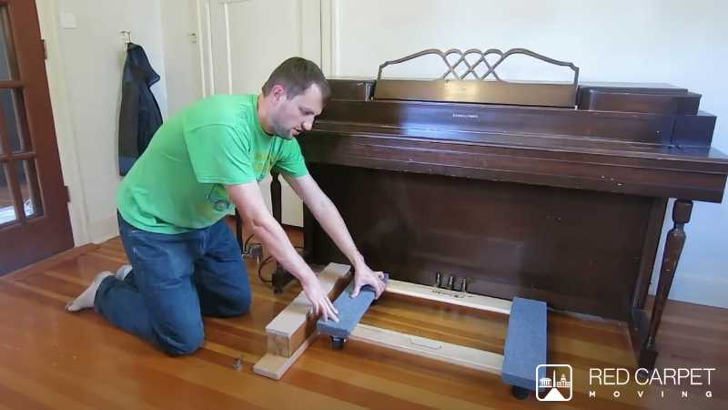 Lifting a piano with a pneumatic jack you have right now.  A basketball or soccer ball and a bike pump.  After you have the dolly under the piano, go to other side with ball and pump up to get block o - Digital concept art for illustrative purpose - Monok