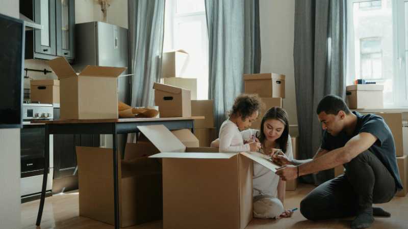 A family unpacks moving boxes in their new home kitchen, creating a cozy atmosphere., tags: smoother - pexel